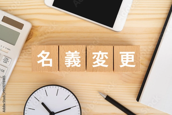 Obraz 名義変更の文字が入ったブロック、電卓、スマホ、時計