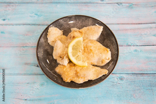 Fototapeta scaloppine al limone is a typical dish of the traditional cuisine of Rome and Lazio in Italy made with veal breaded in flour and cooked with lemon