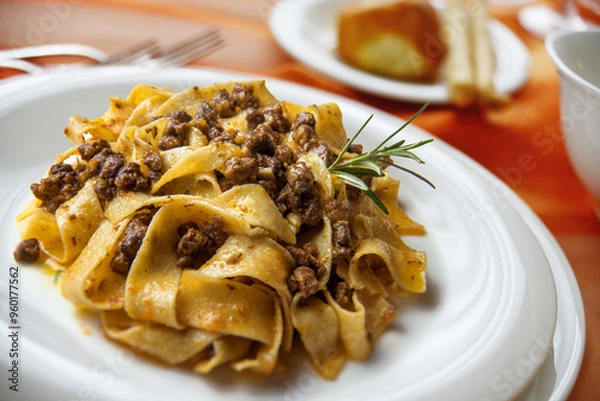 Fototapeta Plate with pappardelle with wild boar ragout sauce on a laid table