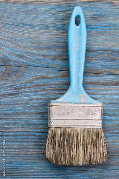 Obraz Used paint brush on blue wooden board with place for text