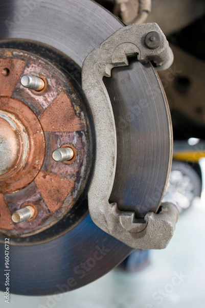 Fototapeta Closeup a disassembled car brake system during maintenance. Front disc brake of a car with a removed wheel. Shallow focus.