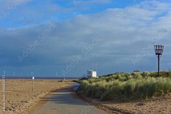 Fototapeta Empty beach during the off-peak season with the lifeguard building in the distance in Skegness UK
