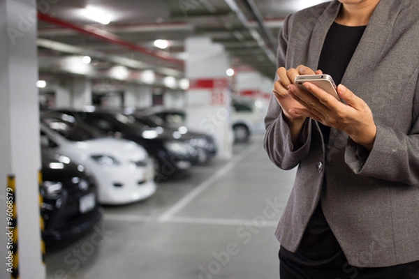 Fototapeta Businesswoman in Underground parking with cars.