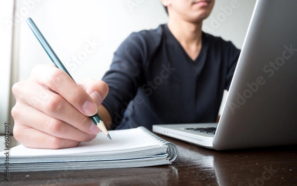 Obraz business man focusing on working with laptop computer and notebook on wooden desk
