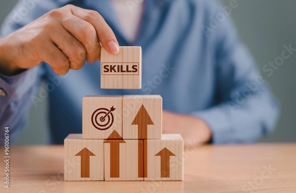 Fototapeta Skill individual development, competency training and education concept. Up new ability skill for business technology evolution. Worker learning upskill. Hand hold wooden cube on digital skill icon.