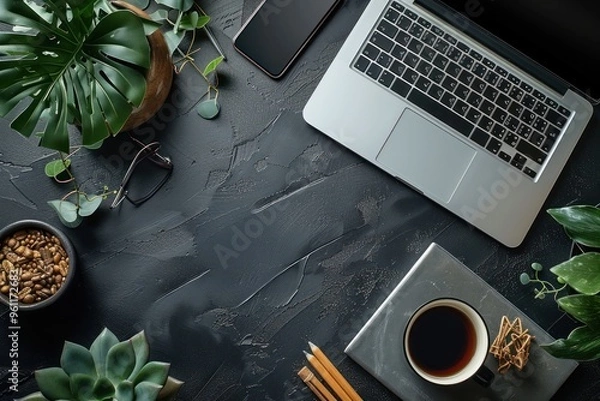 Fototapeta Designer's Essential Workspace: Black Desk with Laptop, Smartphone, Coffee, and Work Supplies - Top View