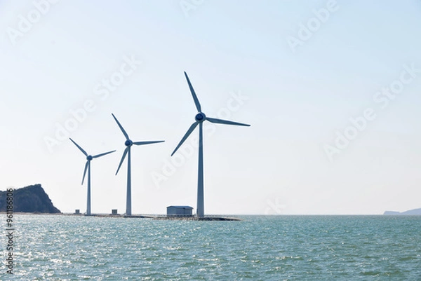 Fototapeta 바람의 힘을 사용하여 풍차를 돌려 전기를 생산하는 바다위의 풍력발전기.