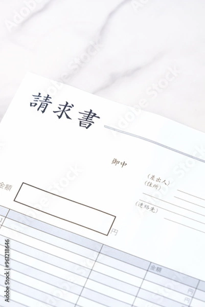 Fototapeta 取引先に宛てた請求書を作成しているビジネスシーンのイメージ
