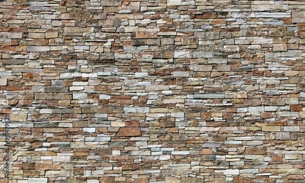 Fototapeta Large stone coating wall made of striped stacked bricks of natural multicolored rocks. Background and texture.