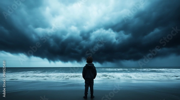 Fototapeta Child standing on a beach, watching a distant hurricane swirl over the ocean with massive dark clouds 