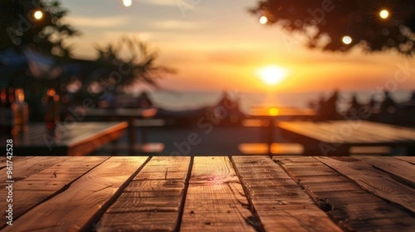 Fototapeta Blurred sunset background with empty wooden table and bar counter.