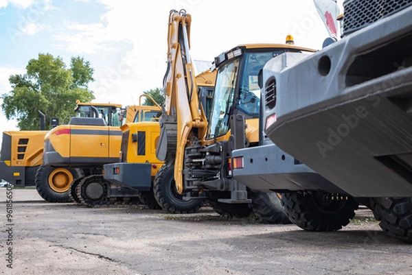 Obraz Yellow construction equipment stands in a row.