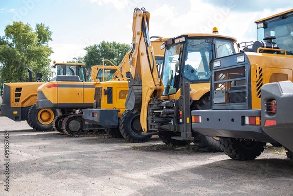 Obraz Yellow construction equipment stands in a row.