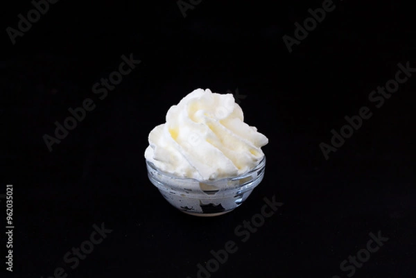 Obraz cream in a glass. whipped cream in a glass bowl on a black background. copy space