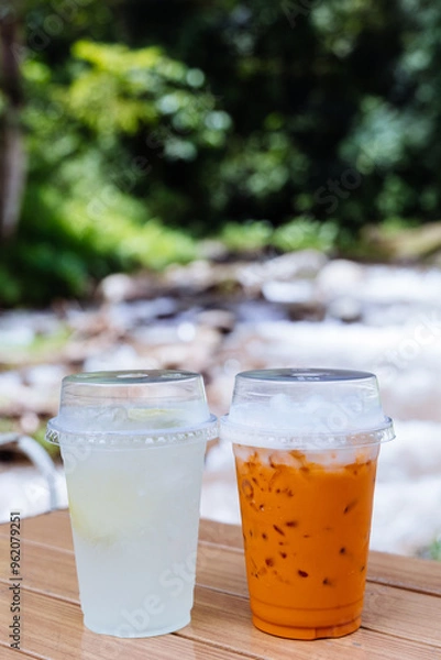 Fototapeta Lemon soda with sliced fresh lemon and Thai tea on the table.