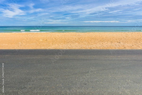 Fototapeta Side view of asphalt road with beach on sea and beautiful blue sky.