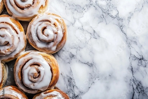 Fototapeta Cinnamon rolls freshly baked with copyspace, icing drizzled on top.