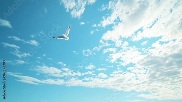 Fototapeta Lone Bird in Tranquil Sky, a serene scene of a solitary bird soaring gracefully through a vast, clear blue expanse, embodying peace and freedom in nature.