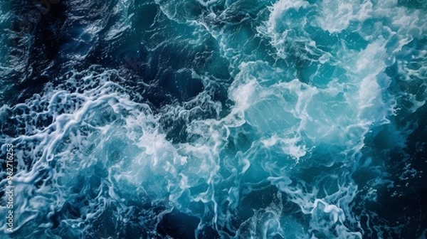 Fototapeta Captivating image of dynamic ocean waves crashing against each other, creating a beautiful pattern of foamy splashes. The deep blue and turquoise hues of the water evoke a sense of power and