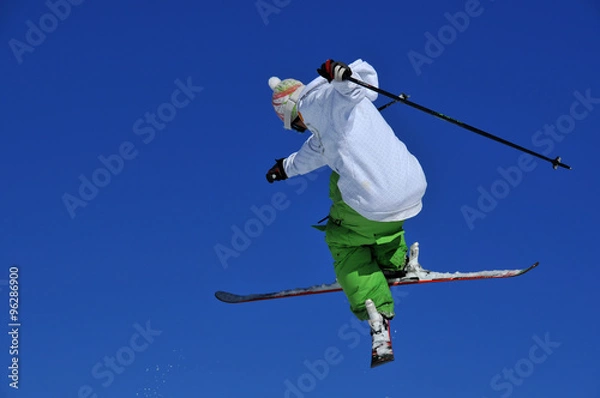 Fototapeta skier in green and white performing a jump