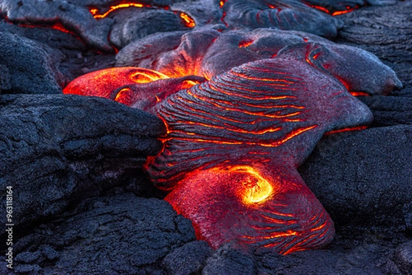 Fototapeta Lava field in Hawaii at night shows oozing lava from the Kilauea eruption forming new rocky surfaces.