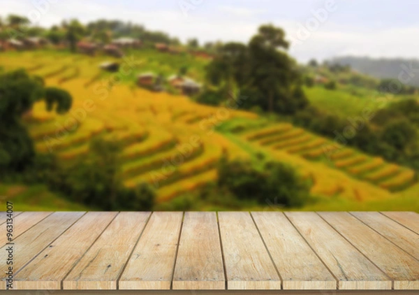 Fototapeta Wooden table top on blur rice field background in daytime.Harvest rice or whole wheat.For montage product display or design key visual layout.View of copy space.