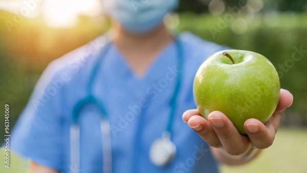 Fototapeta World health day, National nutrition week,an apple a day keeps the doctor away concept by eating high nutritious clean food and healthy nutritional diet with doctor handling green apple to patient