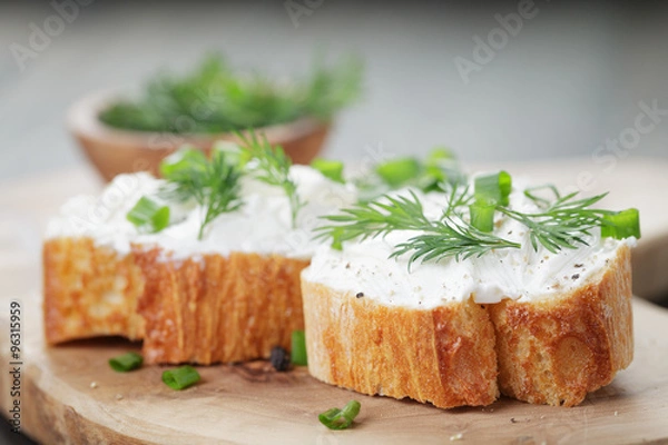 Fototapeta crunchy baguette slices with cream cheese and herbs