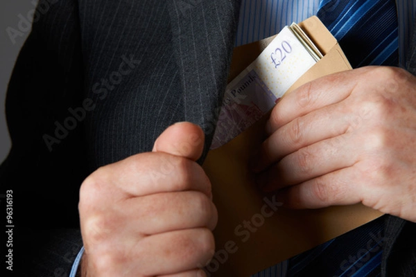 Obraz Biznesmen wkłada kopertę Sterline Notes w kieszeni kurtki