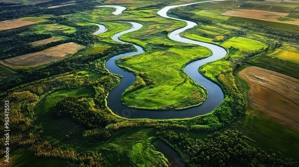 Fototapeta Aerial View of a Serpentine River Winding Through Lush Green Fields and Woodlands