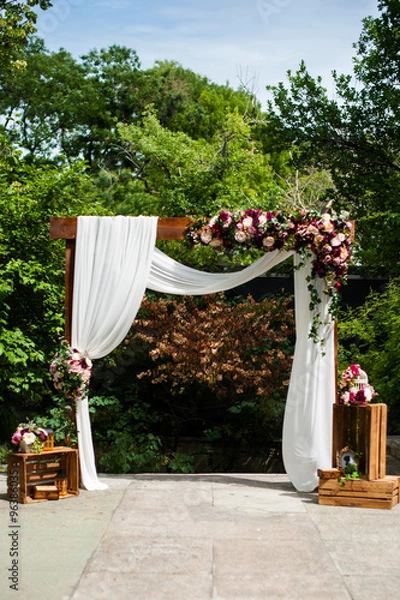 Obraz Wedding arch decorated with cloth and vivid flowers