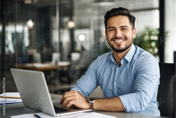 Obraz Smiling businessman working on laptop in office