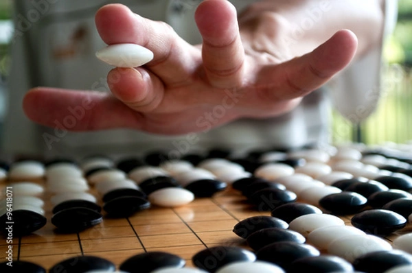 Obraz Go player hand holding white piece