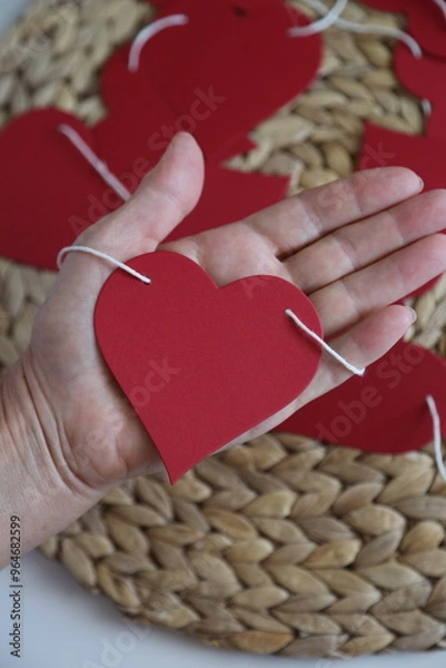 Obraz Hand holding red paper heart garland.