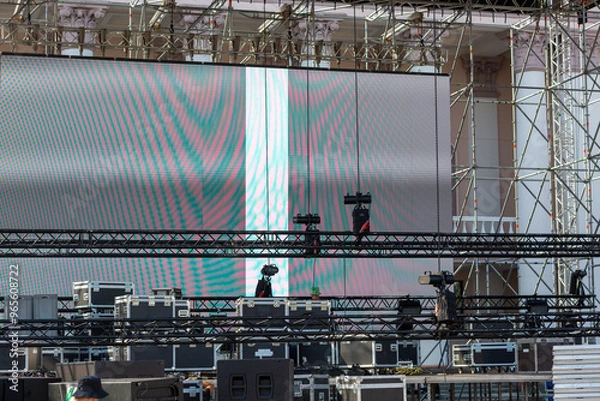 Obraz Stacks of sound equipment and lighting gear are arranged at an outdoor venue, ready for a concert.