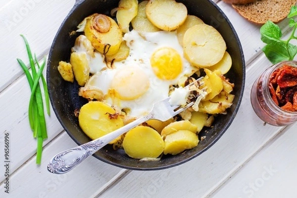Obraz Fried potatoes with fried eggs, breakfast