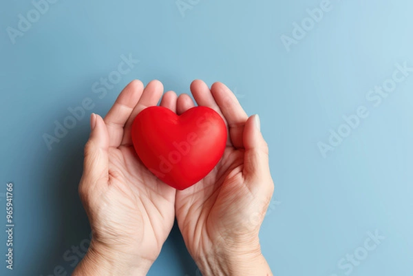 Fototapeta Red  heart in woman's hand support on aging a blue background for promoting health care campaign concept, Heart day, Hear attact, Valentine's day