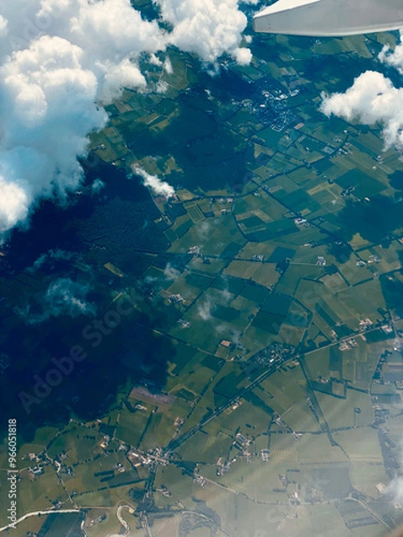 Fototapeta  Aerial view of farmland and buildings from an airplane window during flight.