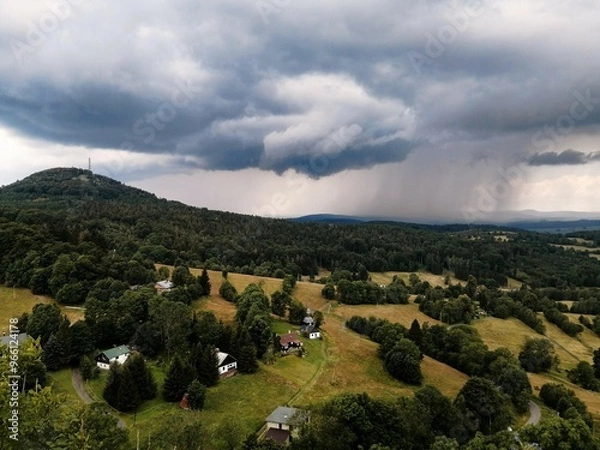 Fototapeta Rainy weather in Bohemian Switzerland. Beautiful cloudy sky. Foggy landscape. Storm over a forest, fields and cottages in the Czech countryside. 