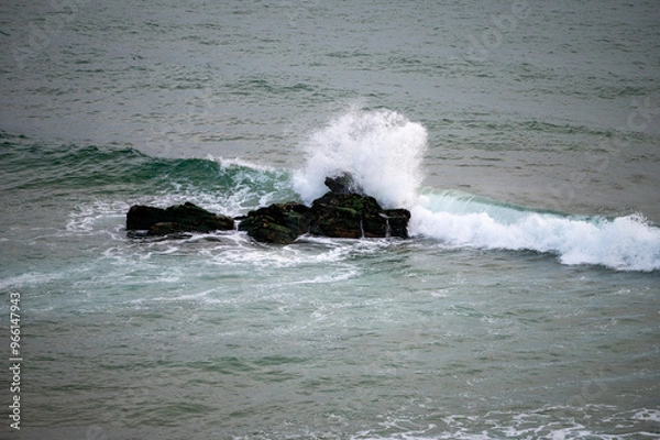 Obraz Der ozean trifft auf einen stein im meer und die welle sprüht gischt