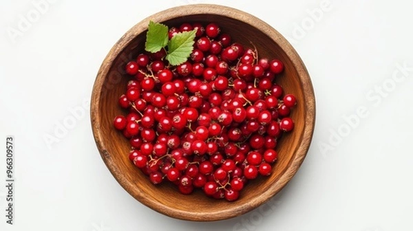 Fototapeta Ripe red currants in a wooden bowl, viewed from above. The vibrant color of the fruit contrasts beautifully with the warm brown of the bowl, suggesting freshness, health, and natural sweetness.