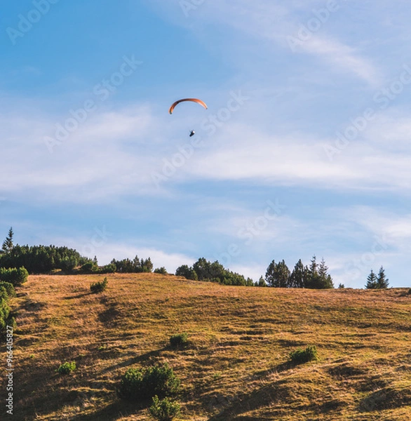 Obraz A paraglider above a hill in the Bavarian Alps, southern Germany. The skies are clear and blue.