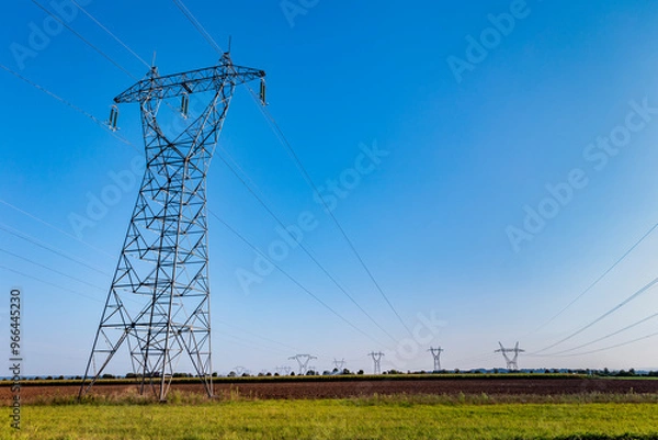 Fototapeta High voltage pylon in the French countryside. High voltage electric power grid. High voltage power line in an agricultural landscape.