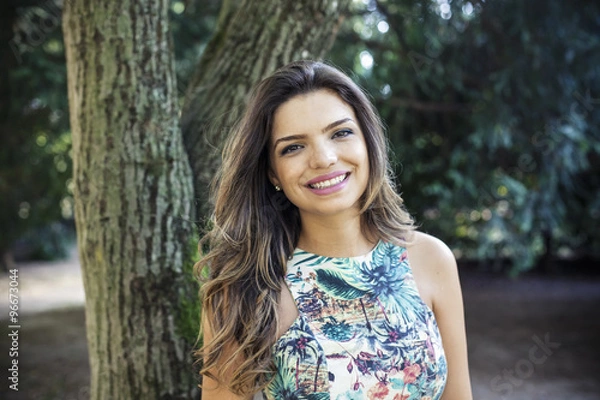 Fototapeta Portrait of a young girl smiling with nature background