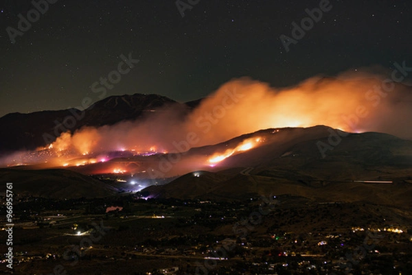 Fototapeta Long exposure night time, Davis fire burning in Washoe Valley on both sides of I-580 around the Galena Creek Bridge with emergency vehicles and firefighting stations lighting up the hills.