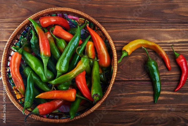 Fototapeta Close up of an assortment of peppers and chillies in a basket