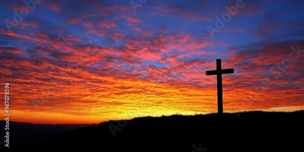 Obraz A cross silhouetted against a vibrant sunrise on the horizon 
