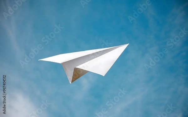 Fototapeta A photo of a paper airplane in mid-flight against a clear blue sky.