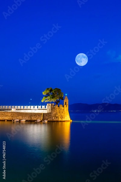 Fototapeta Nafpaktos port in Greek during blue hour against the full moon. A famous touristic destination.
