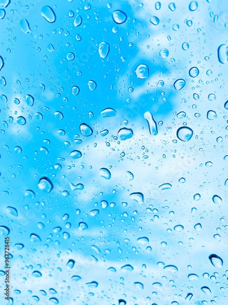 Obraz 雨の水滴がついている窓ガラス越しに見える青空